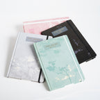 A5 Seasons notebook by 2BE with colorful cover featuring seasonal illustrations and lined pages.