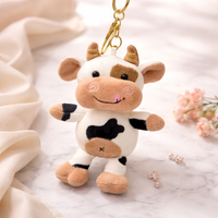 Givana cute plush cow keychain with golden clasp, soft fabric cow figure with detailed facial features and small horns.