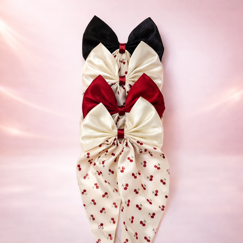 Cherry Babe Clip-On Bow by Givana in four colors, featuring a cute cherry design and vibrant fabric for stylish accessory looks.