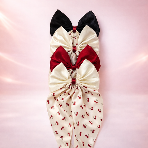 Cherry Babe Clip-On Bow by Givana in four colors, featuring a cute cherry design and vibrant fabric for stylish accessory looks.
