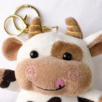Givana cute plush cow keychain with golden clasp, soft stuffed animal accessory for keys or bags featuring a cute cow design.
