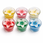 Givana Bloom Glow Mini Candle in six colorful shades, featuring a small glass container with a lit flame and floral design.