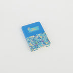A6 floral notebook by 2BE featuring a vibrant flower design on a textured cover.