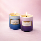 Givana Deluxe Aromatic Candle in two shades, featuring a stylish glass holder and softly glowing flame for a cozy ambiance.